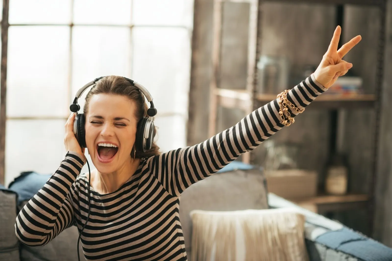 a young woman wearing headphones is singing a song